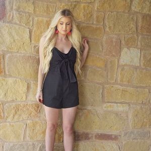 Black romper with bow on front.